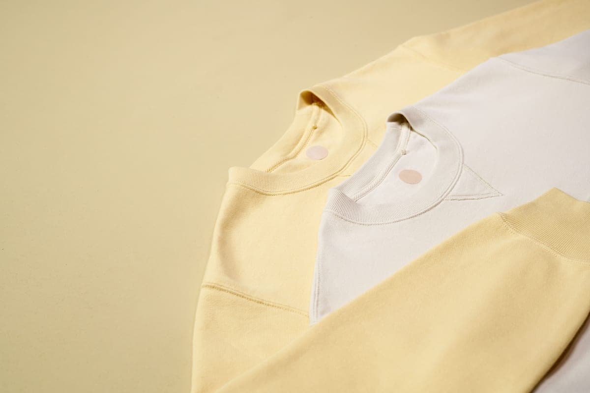 A jacket and a hooded sweatshirt laid side by side on a pale background.