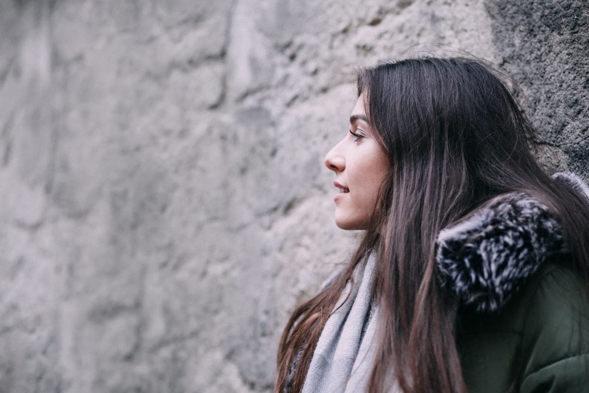 Two winter jackets side by side against a pale wall in flat daylight.