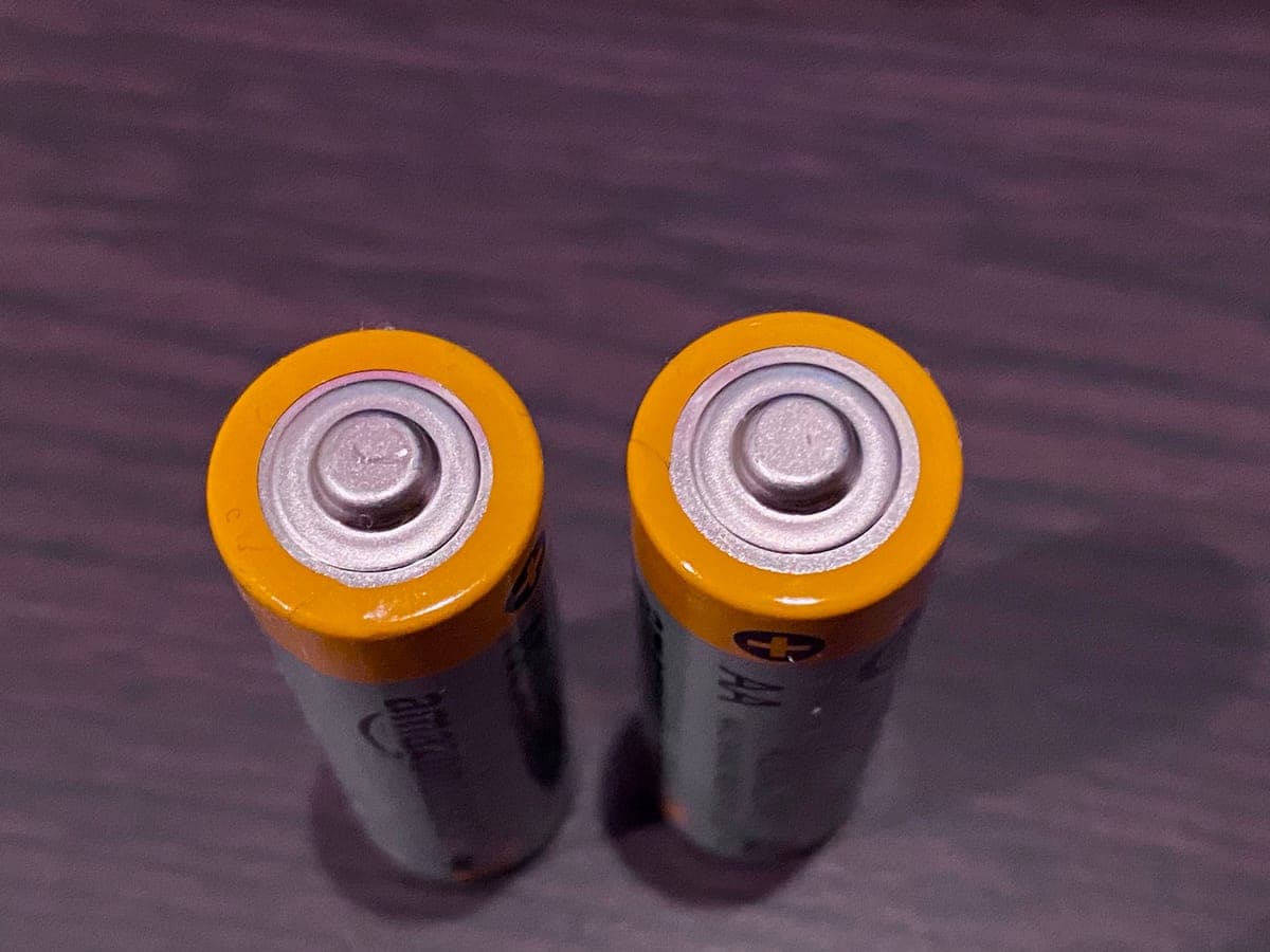 A battery pack and its certification label photographed on a pale surface in even daylight.