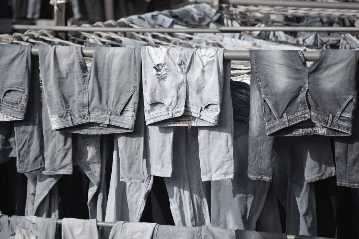 A jacket laid flat to dry on a pale surface beside a disconnected battery pack.