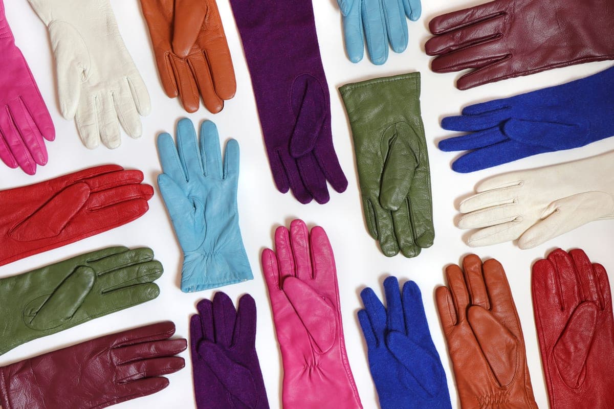 Insulated heated gloves laid on a pale surface with their battery packs beside them.