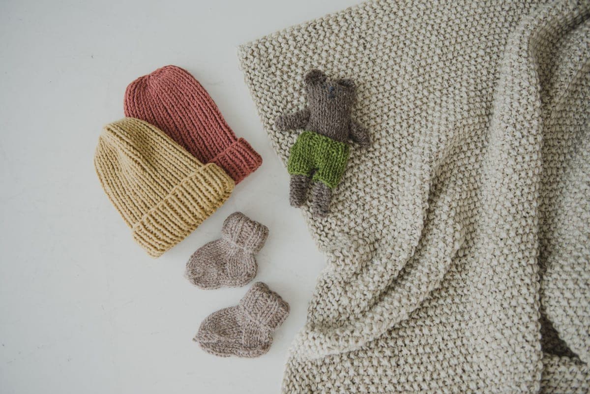 Heated socks with cuff battery pouches laid flat on a pale surface in even daylight.