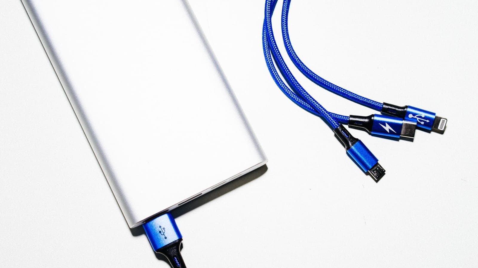 Minimalist image of a power bank with blue USB charging cables on a white background.