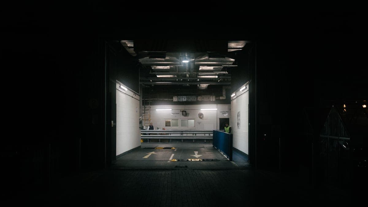 Work boots on a cold concrete warehouse floor in pale flat light.